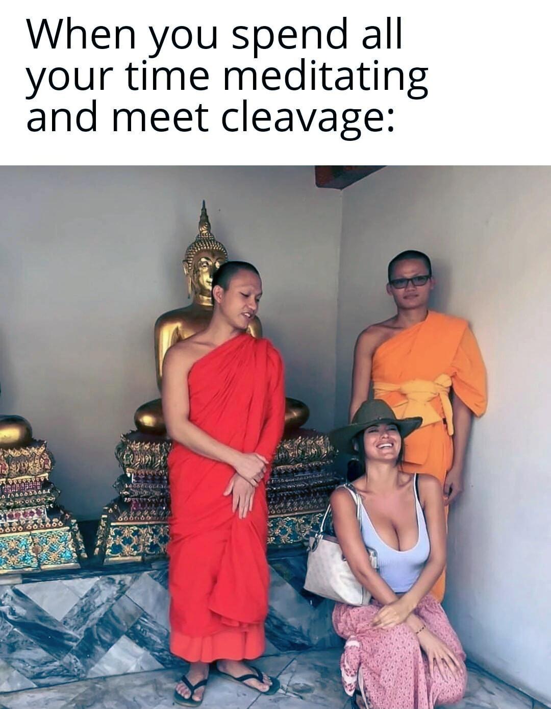 Two monks in orange robes and a woman with visible cleavage sit in a temple setting with gold statues.